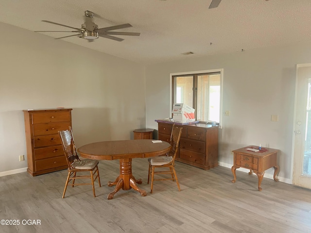 dining room with baseboards, ceiling fan, and light wood finished floors