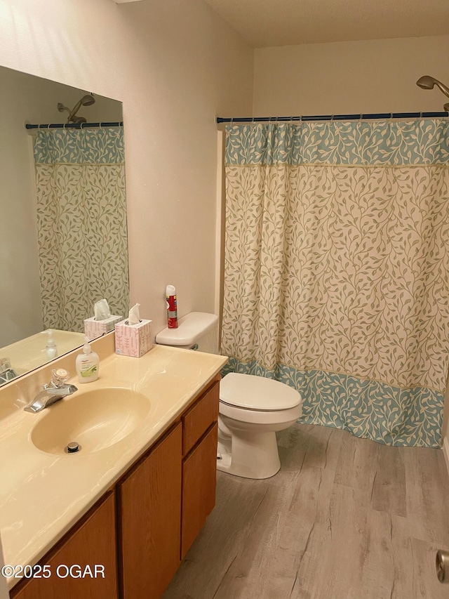 full bathroom featuring curtained shower, vanity, toilet, and wood finished floors