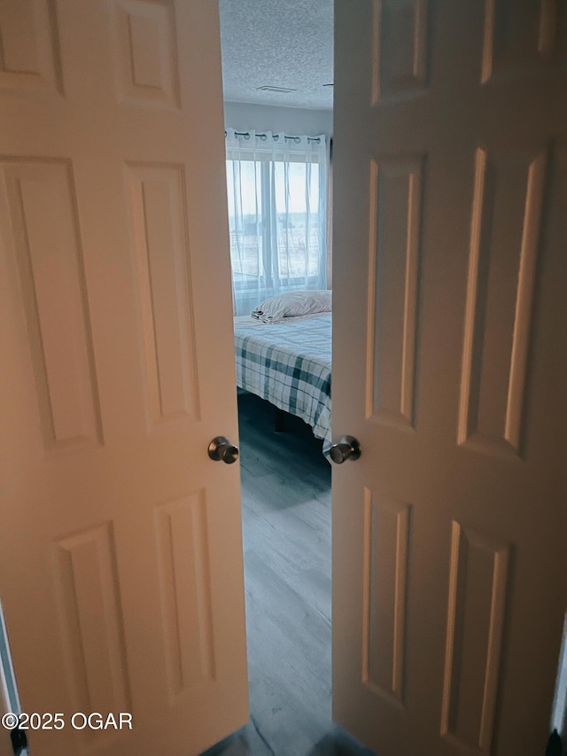 bedroom featuring a textured ceiling and wood finished floors