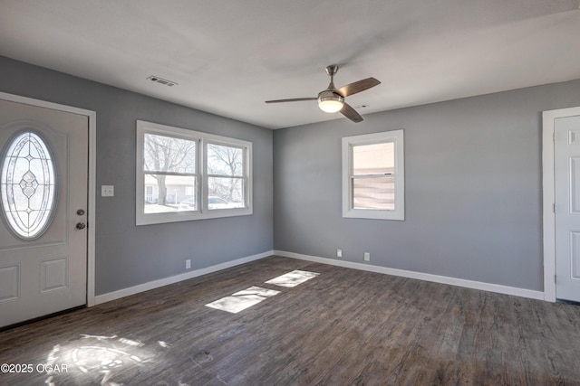 entryway featuring dark wood-type flooring, a ceiling fan, visible vents, and baseboards