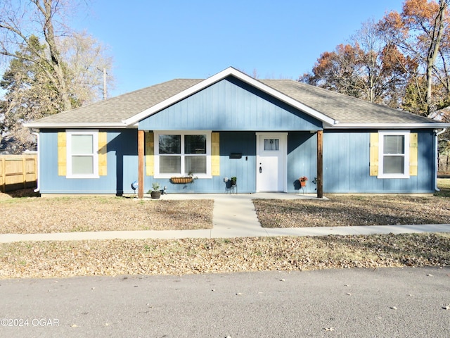 view of front of property featuring fence and roof with shingles