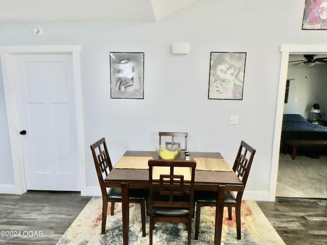 dining space with lofted ceiling, dark wood-style flooring, and baseboards