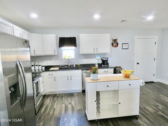 kitchen featuring appliances with stainless steel finishes, white cabinetry, a sink, and dark wood-type flooring