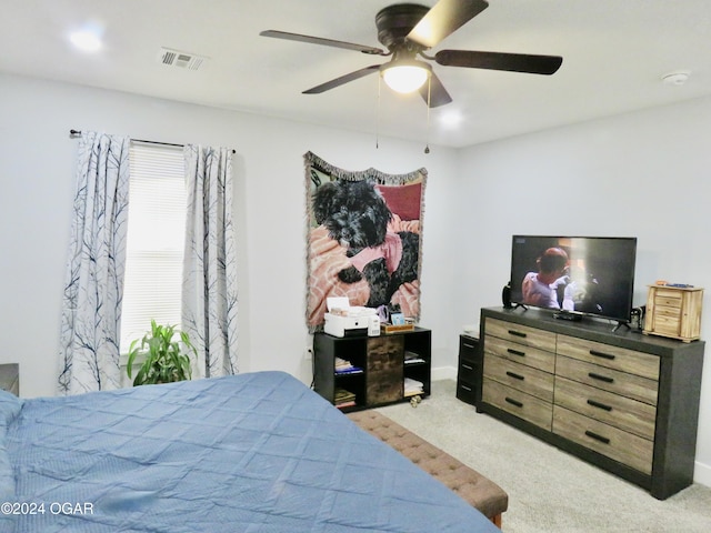 bedroom with light carpet, visible vents, and a ceiling fan