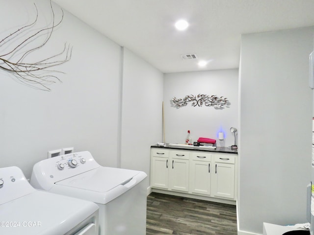 clothes washing area with visible vents, dark wood-style flooring, cabinet space, and washer and clothes dryer