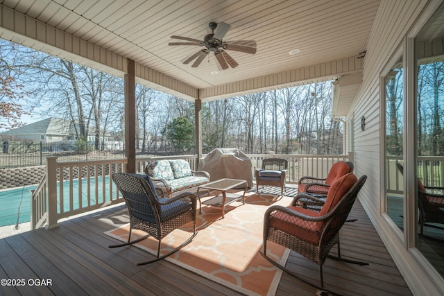 deck featuring an outdoor living space, ceiling fan, and fence