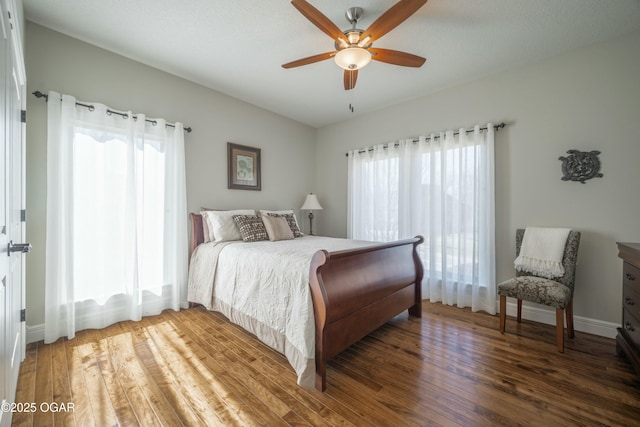 bedroom featuring ceiling fan, baseboards, and wood finished floors