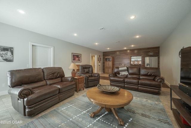 living room featuring visible vents, recessed lighting, an accent wall, and baseboards