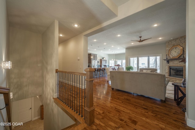 living room with wood finished floors, baseboards, a fireplace, recessed lighting, and ceiling fan