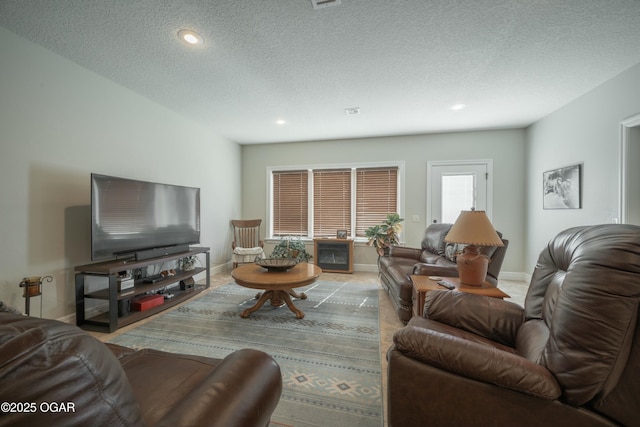 living area featuring recessed lighting, visible vents, baseboards, and a textured ceiling