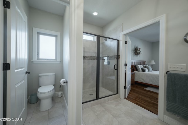 bathroom with tile patterned flooring, connected bathroom, baseboards, toilet, and a stall shower