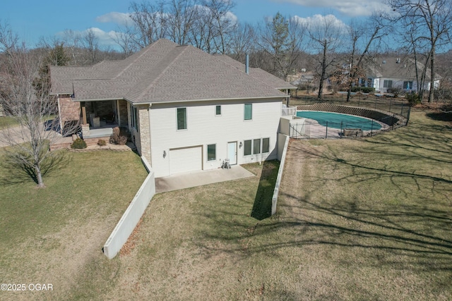 rear view of house featuring a fenced in pool, a shingled roof, fence, a lawn, and a patio area