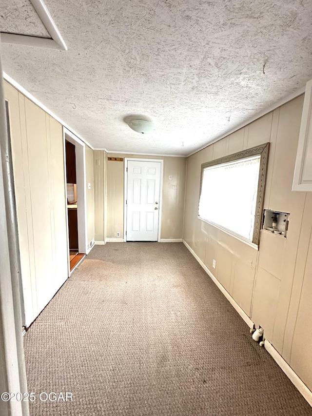 unfurnished bedroom featuring a closet, a textured ceiling, a decorative wall, and carpet flooring