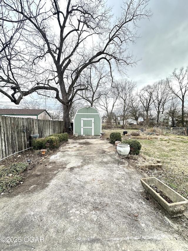 view of patio / terrace with a storage unit, an outdoor structure, and fence