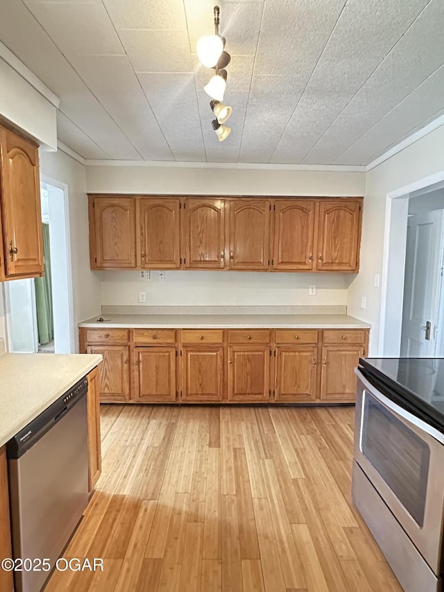 kitchen with light countertops, appliances with stainless steel finishes, brown cabinetry, and light wood-style flooring