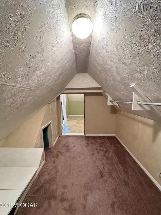 bonus room with carpet flooring, vaulted ceiling, a textured ceiling, and baseboards