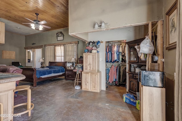 bedroom featuring concrete flooring, wooden ceiling, a high ceiling, a closet, and a walk in closet