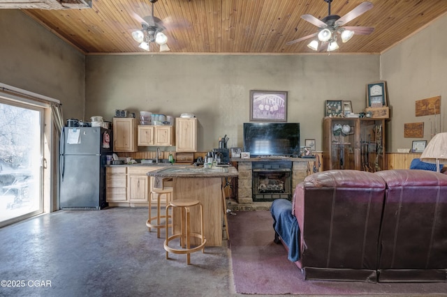 living room with finished concrete flooring, wooden ceiling, ceiling fan, and a fireplace