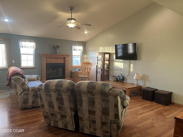 living area featuring lofted ceiling, ceiling fan, wood finished floors, a fireplace, and recessed lighting