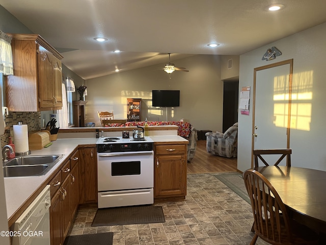 kitchen with lofted ceiling, a peninsula, white appliances, open floor plan, and light countertops