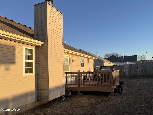 exterior space with a deck, a chimney, and fence