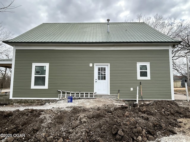 back of house featuring metal roof