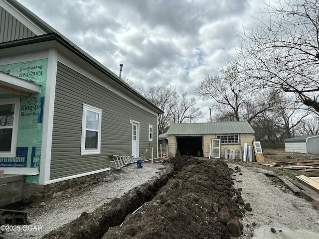 view of side of property with an outdoor structure, a garage, and board and batten siding