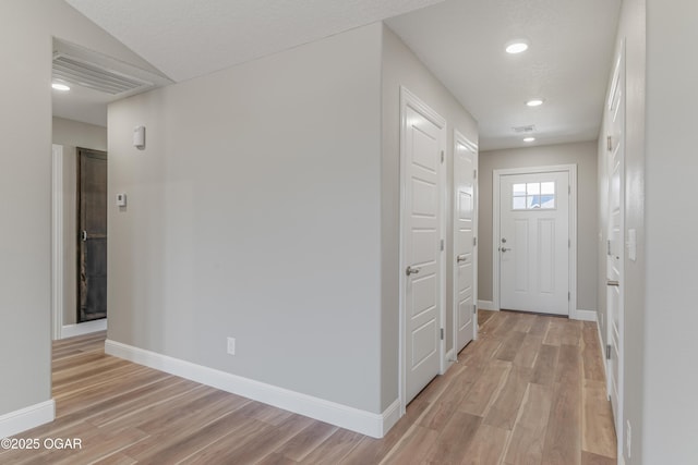 corridor with visible vents, recessed lighting, light wood-style floors, and baseboards