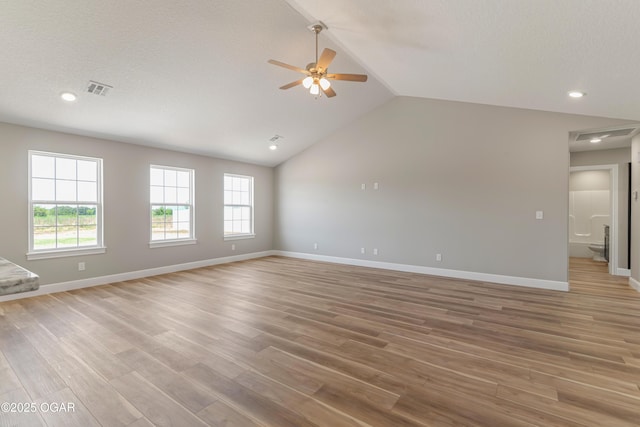 unfurnished living room with lofted ceiling, visible vents, light wood-type flooring, and baseboards