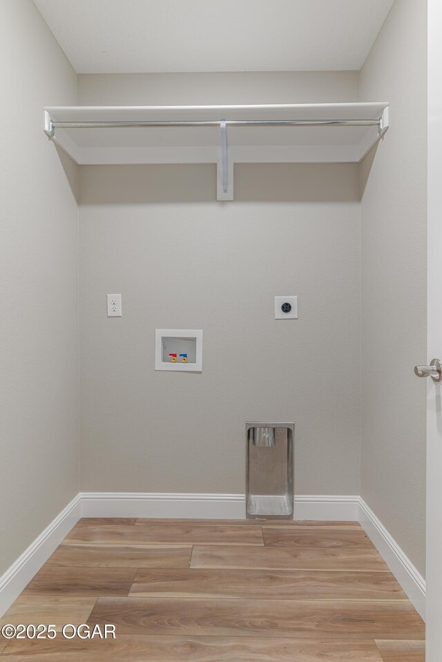 clothes washing area with hookup for a washing machine, baseboards, laundry area, light wood-style flooring, and electric dryer hookup