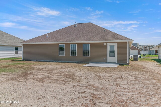 back of house featuring a patio area, central AC, and a shingled roof