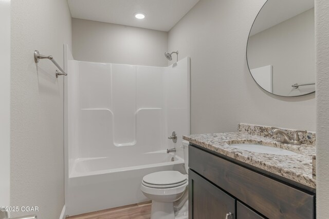 full bathroom with vanity, toilet, wood finished floors, and shower / bath combination