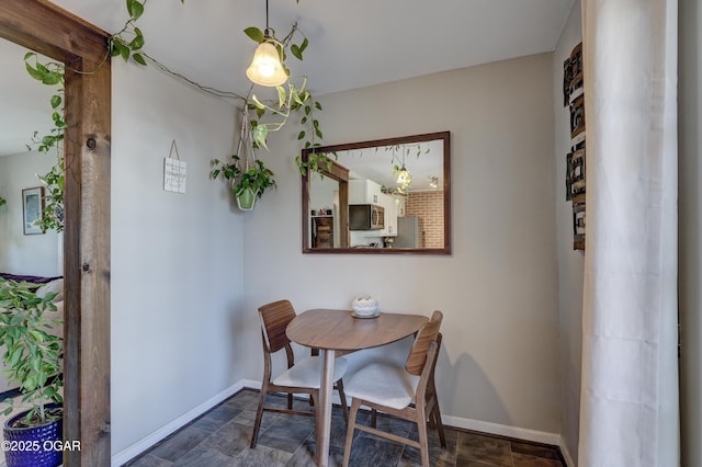 dining area featuring stone finish floor and baseboards