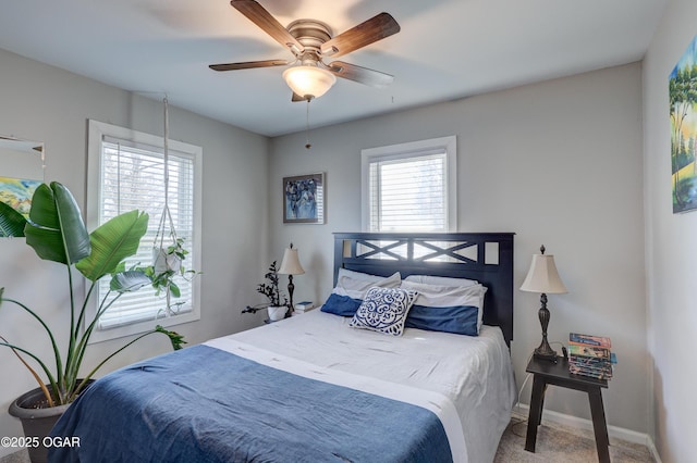 bedroom with ceiling fan, carpet floors, multiple windows, and baseboards