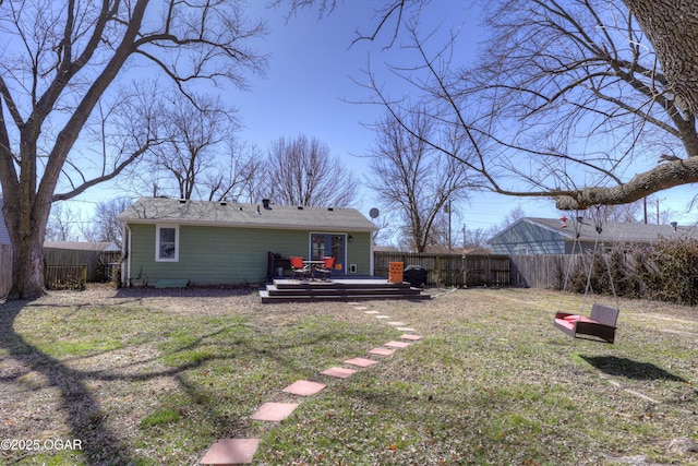 back of house with a fenced backyard, a yard, and a deck