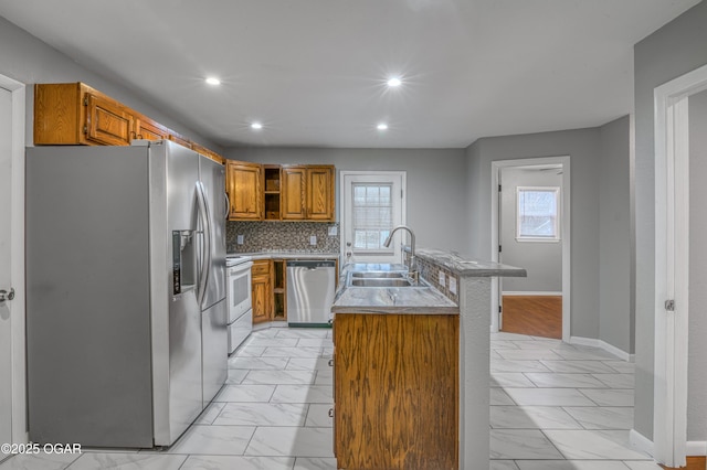 kitchen featuring stainless steel appliances, marble finish floor, brown cabinets, and a sink