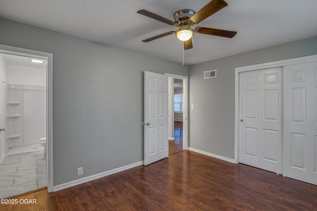 unfurnished bedroom with baseboards, visible vents, connected bathroom, wood finished floors, and a closet