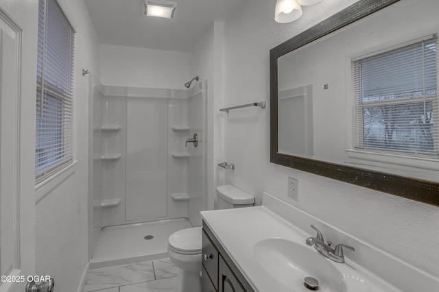 full bathroom featuring marble finish floor, vanity, toilet, and walk in shower