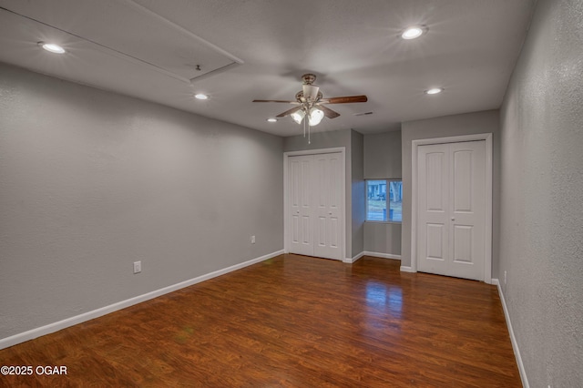 unfurnished bedroom with two closets, recessed lighting, a ceiling fan, wood finished floors, and baseboards