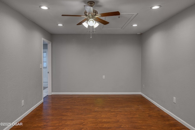 empty room featuring recessed lighting, wood finished floors, attic access, and baseboards