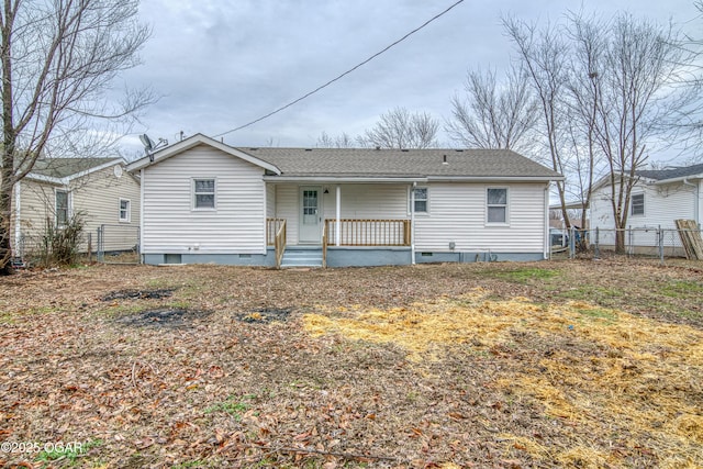 rear view of property with crawl space, covered porch, a shingled roof, and fence