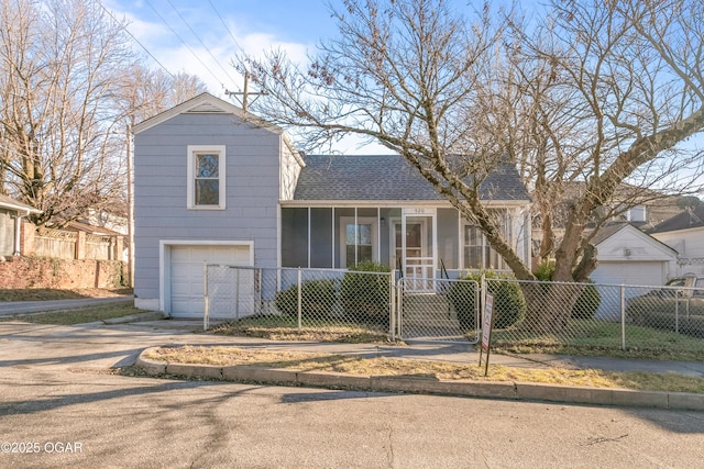 tri-level home with a fenced front yard, roof with shingles, an attached garage, a gate, and driveway