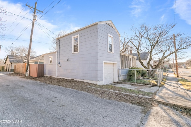 view of side of property featuring a garage and fence