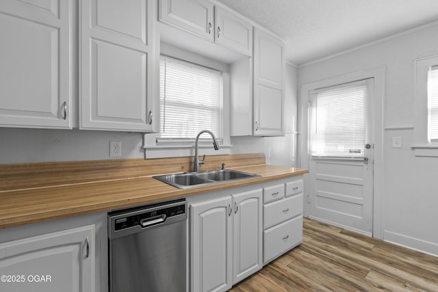 kitchen featuring white cabinets, dishwasher, butcher block counters, wood finished floors, and a sink