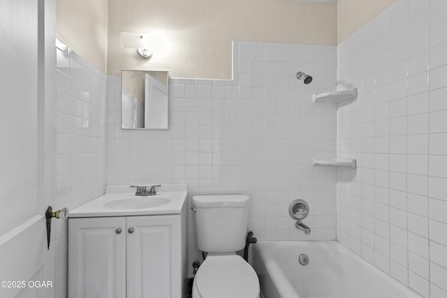 bathroom featuring toilet, tile walls, vanity, and bathing tub / shower combination