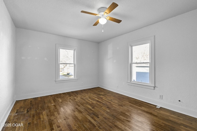 empty room featuring hardwood / wood-style flooring, ceiling fan, baseboards, and a textured ceiling