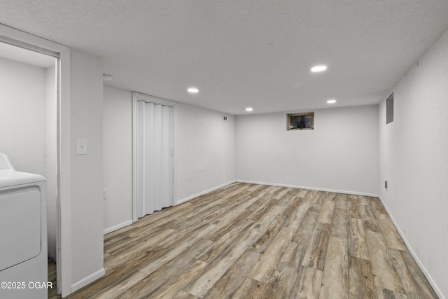 finished below grade area featuring recessed lighting, wood finished floors, washer / dryer, and baseboards