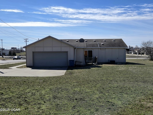 view of front of home featuring a garage, a front yard, concrete driveway, and a shingled roof