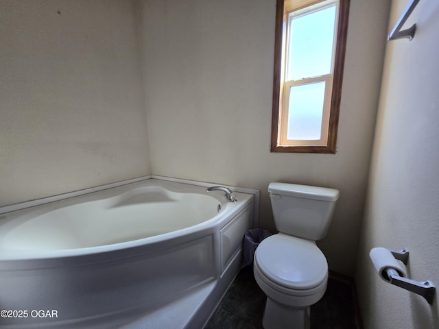 bathroom with a garden tub and toilet