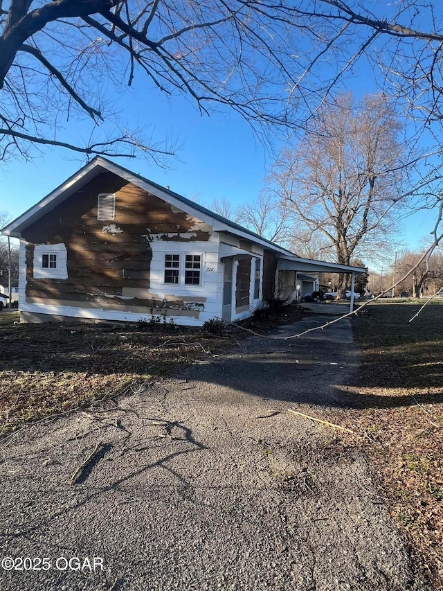 view of home's exterior with a carport and aphalt driveway